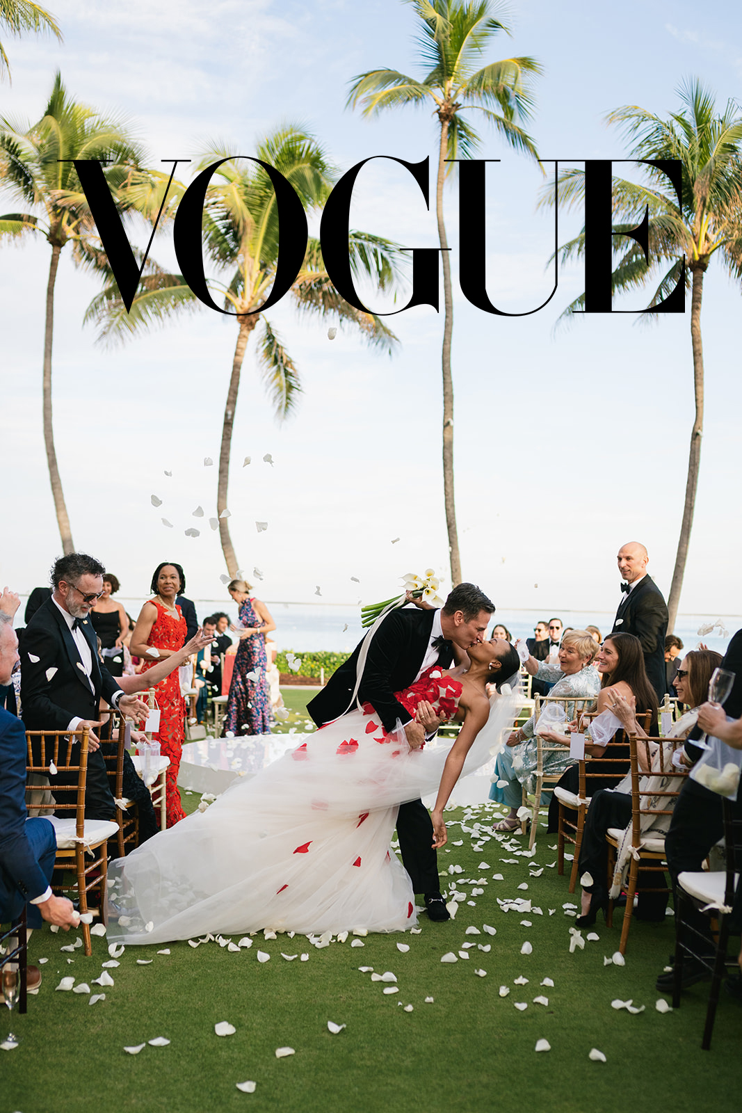Anna-Kay and Ross wedding at The Breakers Palm Beach — groom dipping bride in a recessional kiss as white rose petals fall around them, ocean and palm trees behind them | Sunny Lee Photography